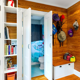 Exempel på ett litet eklektiskt kapprum, med bruna väggar, mellanmörkt trägolv och brunt golv