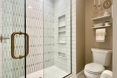Example of a mid-sized transitional master white tile and marble tile porcelain tile, white floor, double-sink and wainscoting bathroom design in Other with recessed-panel cabinets, white cabinets, a two-piece toilet, brown walls, an undermount sink, quartz countertops, a hinged shower door, white countertops and a built-in vanity