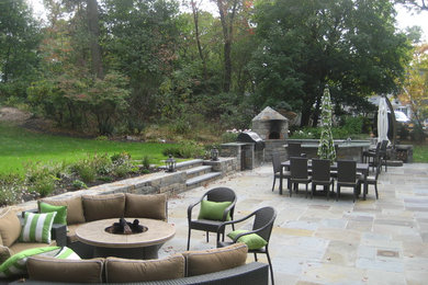 Photo of a large traditional backyard patio in New York with a fire feature, natural stone pavers and no cover.