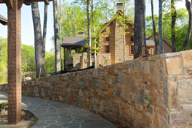 Photo of a mid-sized rustic backyard stone landscaping in Other.