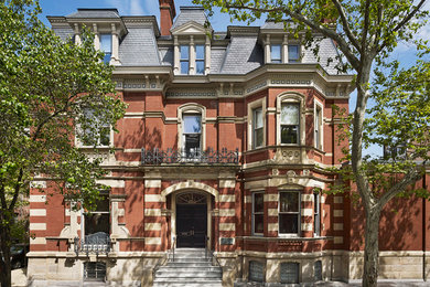 Huge victorian red three-story brick flat roof idea in Philadelphia