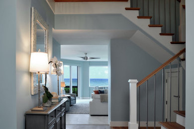 Entryway - coastal medium tone wood floor entryway idea in Miami with blue walls