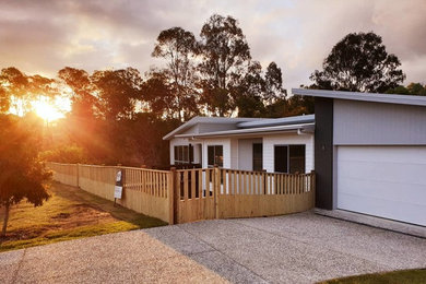 Photo of a large beach style one-storey concrete white house exterior in Gold Coast - Tweed with a shed roof and a tile roof.