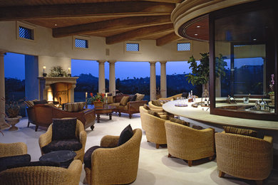 Inspiration for a large mediterranean backyard patio remodel in Los Angeles with a fireplace and a roof extension