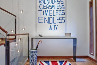 Entryway - contemporary painted wood floor entryway idea in New York with white walls