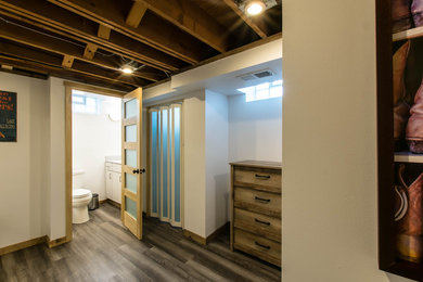 Inspiration for a mid-sized rustic underground vinyl floor and brown floor basement remodel in Other with beige walls