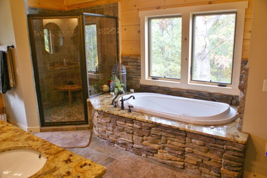 Immagine di una grande stanza da bagno padronale rustica con vasca da incasso, doccia ad angolo, piastrelle grigie, piastrelle in gres porcellanato e pavimento con piastrelle di ciottoli