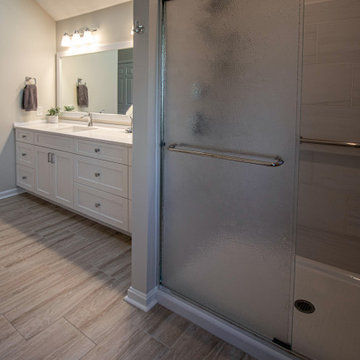 White Vanity with Freestanding Tub and Tiled Shower with Closet Storage
