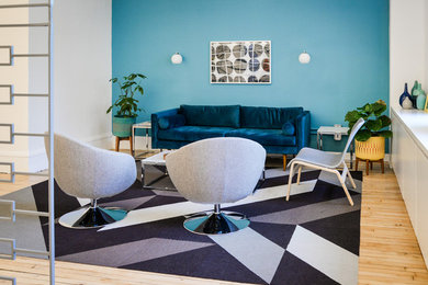 Inspiration for a mid-sized 1960s open concept light wood floor living room remodel in New York with blue walls, no fireplace and no tv