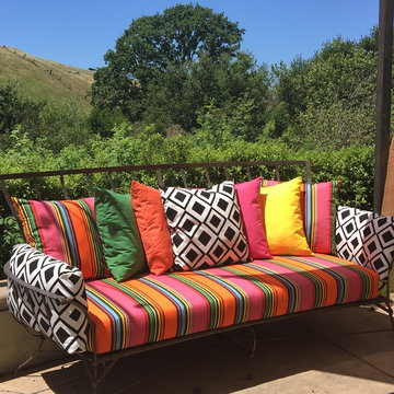 A rainbow of Sunbrella pillows brightens backyard retreat
