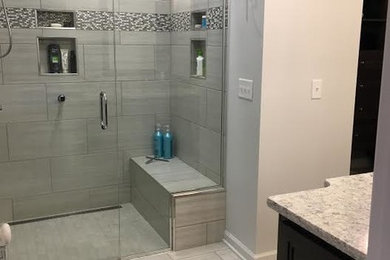 Inspiration for a mid-sized transitional master gray tile and porcelain tile porcelain tile and beige floor alcove shower remodel in Other with recessed-panel cabinets, dark wood cabinets, beige walls, an undermount sink, granite countertops and a hinged shower door