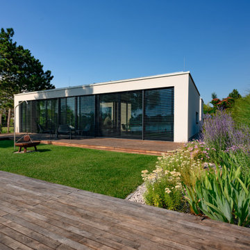 Moderner Seegarten mit großzügiger Holzterrasse