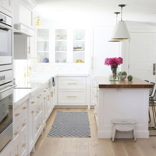 Kitchen pantry appliance - Inspiration for a light wood floor kitchen pantry remodel in Salt Lake City with white cabinets, marble countertops, white backsplash and an island