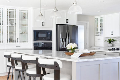 Huge transitional l-shaped open concept kitchen photo in Orlando with shaker cabinets, white cabinets, quartz countertops, white backsplash, quartz backsplash, black appliances, two islands and white countertops