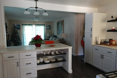 Enclosed kitchen - mid-sized traditional l-shaped dark wood floor and brown floor enclosed kitchen idea in Phoenix with raised-panel cabinets, white cabinets, marble countertops, stainless steel appliances and a peninsula