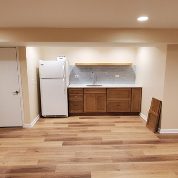 Finished basement kitchenette at 99% completion with floating shelf and tile bac