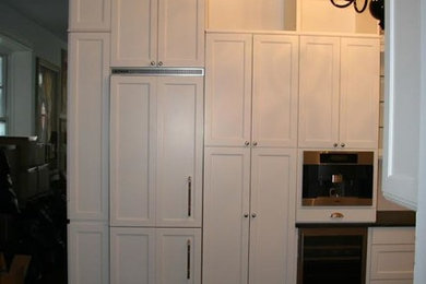 Diseño de cocinas en U bohemio pequeño con armarios estilo shaker, puertas de armario blancas, salpicadero blanco y electrodomésticos de acero inoxidable