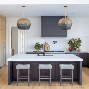 Custom Kitchen with Dark Island, Light Wood Cabinetry & Statement Pendants