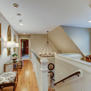 Klassisk inredning av en mellanstor hall, med beige väggar, ljust trägolv och brunt golv