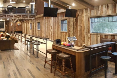 Inspiration for a huge rustic loft-style game room remodel in Other with a stone fireplace, a wood stove and a media wall