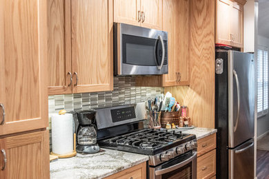 Open concept kitchen - mid-sized transitional single-wall dark wood floor and brown floor open concept kitchen idea in New York with shaker cabinets, medium tone wood cabinets, quartz countertops, gray backsplash, mosaic tile backsplash, stainless steel appliances, an island and gray countertops