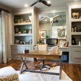 Inredning av ett lantligt hemmabibliotek, med mörkt trägolv och ett fristående skrivbord