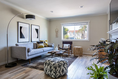 Photo of a beach style living room in San Diego with light hardwood floors and a standard fireplace.
