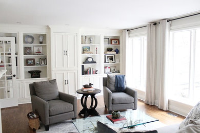 Large transitional open concept medium tone wood floor family room photo in Toronto with gray walls, a standard fireplace, a brick fireplace and a concealed tv