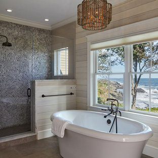 Inspiration pour une douche en alcôve principale marine avec une baignoire indépendante, un carrelage multicolore, une plaque de galets, un mur beige, un sol marron et une cabine de douche à porte battante.