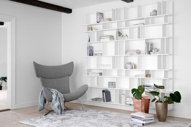 Mid-sized trendy enclosed light wood floor and beige floor living room library photo in Philadelphia with white walls, no fireplace and no tv