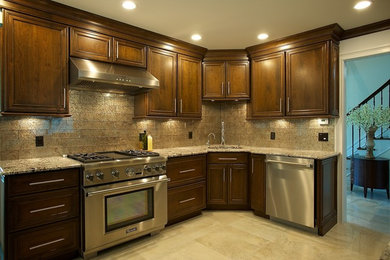 This is an example of a mid-sized traditional l-shaped separate kitchen in New York with an undermount sink, recessed-panel cabinets, dark wood cabinets, granite benchtops, beige splashback, glass tile splashback, stainless steel appliances, ceramic floors, no island and beige floor.