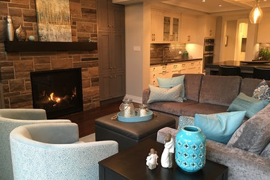 Family room - mid-sized transitional open concept family room idea in Toronto with gray walls, a standard fireplace, a stone fireplace and a media wall