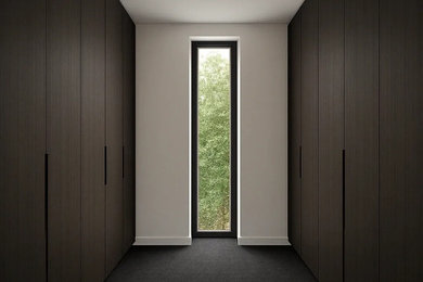 This is an example of a mid-sized modern gender-neutral walk-in wardrobe in Melbourne with dark wood cabinets, carpet and grey floor.