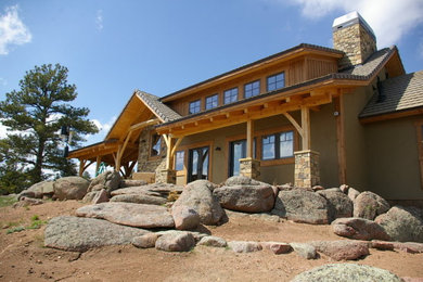 Inspiration for a large traditional partial sun front yard stone landscaping in Denver.
