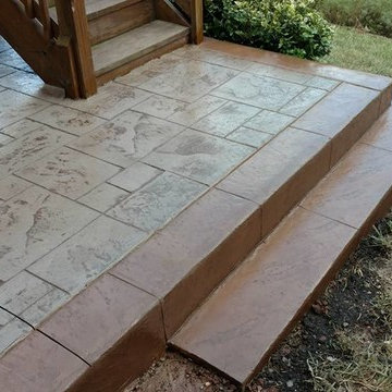J-Stamped concrete patio with a step under the wood deck