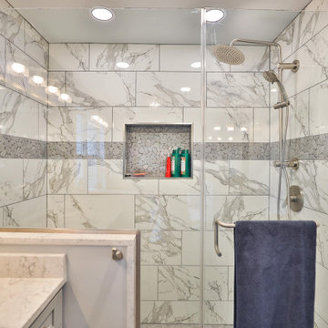 Master bathroom remodel in Poquoson with corner bathtub & marble lined tiles