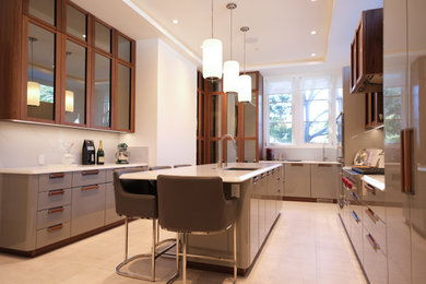 Inspiration for a large modern u-shaped limestone floor, beige floor and tray ceiling enclosed kitchen remodel in San Francisco with an undermount sink, glass-front cabinets, dark wood cabinets, quartz countertops, white backsplash, quartz backsplash, stainless steel appliances, an island and white countertops