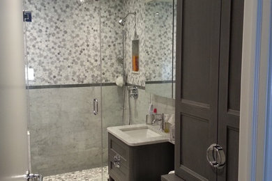 Example of a mid-sized transitional master black and white tile and subway tile porcelain tile doorless shower design in New York with recessed-panel cabinets, gray cabinets, a one-piece toilet, gray walls, an undermount sink and marble countertops