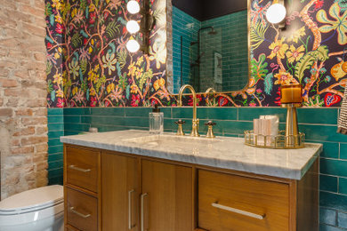 Inspiration for an eclectic turquoise tile marble floor, multicolored floor, single-sink, brick wall and wallpaper bathroom remodel in New Orleans with flat-panel cabinets, medium tone wood cabinets, multicolored walls, an undermount sink, gray countertops and a freestanding vanity