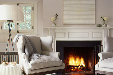 Mid-sized beach style enclosed painted wood floor living room photo in New York with gray walls, a standard fireplace, a wood fireplace surround and no tv