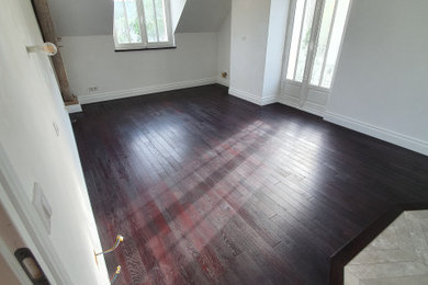 ルアーブルにある広いトランジショナルスタイルのおしゃれな主寝室 (白い壁、濃色無垢フローリング、暖炉なし、赤い床)