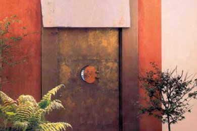 Example of a mid-sized trendy single front door design in Los Angeles with orange walls and a brown front door