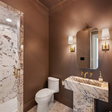 Vaulted Luxury Bathroom with Integrated Marble Vanity and Brass Accents