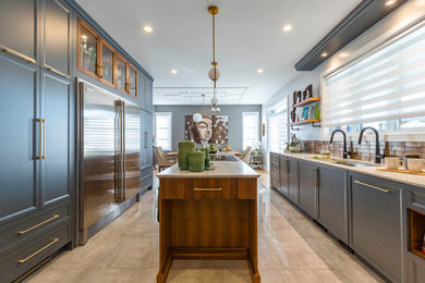 Example of a large trendy porcelain tile and gray floor kitchen design in Other with an undermount sink, recessed-panel cabinets, gray cabinets, solid surface countertops, brown backsplash, metal backsplash, paneled appliances, an island and white countertops