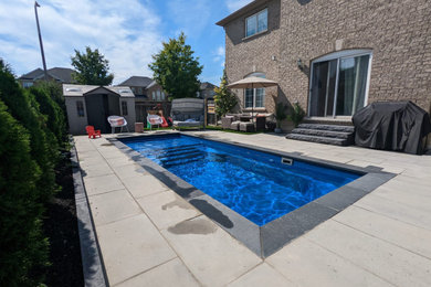Example of a small minimalist backyard concrete paver and rectangular pool landscaping design in Toronto
