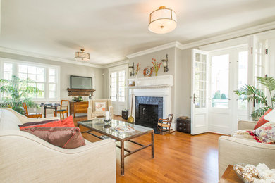 Living room - traditional medium tone wood floor living room idea in Boston with gray walls, a standard fireplace and a brick fireplace