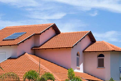 White three-story exterior home idea in Orlando with a tile roof