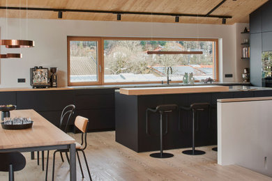 Idées déco pour une très grande cuisine ouverte contemporaine avec des portes de placard noires.