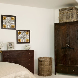 Foto di una camera matrimoniale etnica di medie dimensioni con pareti beige e pavimento in legno verniciato