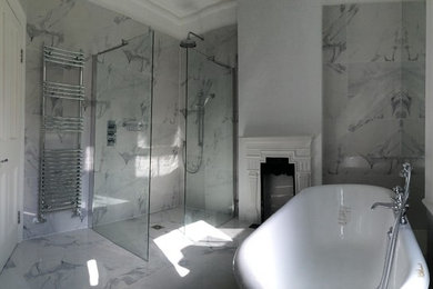 This is an example of a mid-sized contemporary master bathroom in London with white tile, a console sink, a claw-foot tub, a curbless shower, a two-piece toilet, porcelain tile, white walls and porcelain floors.